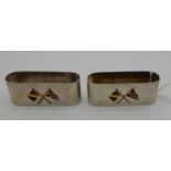 A pair of silver napkin rings by John William Barrett, Birmingham 1931, each inset with enamel