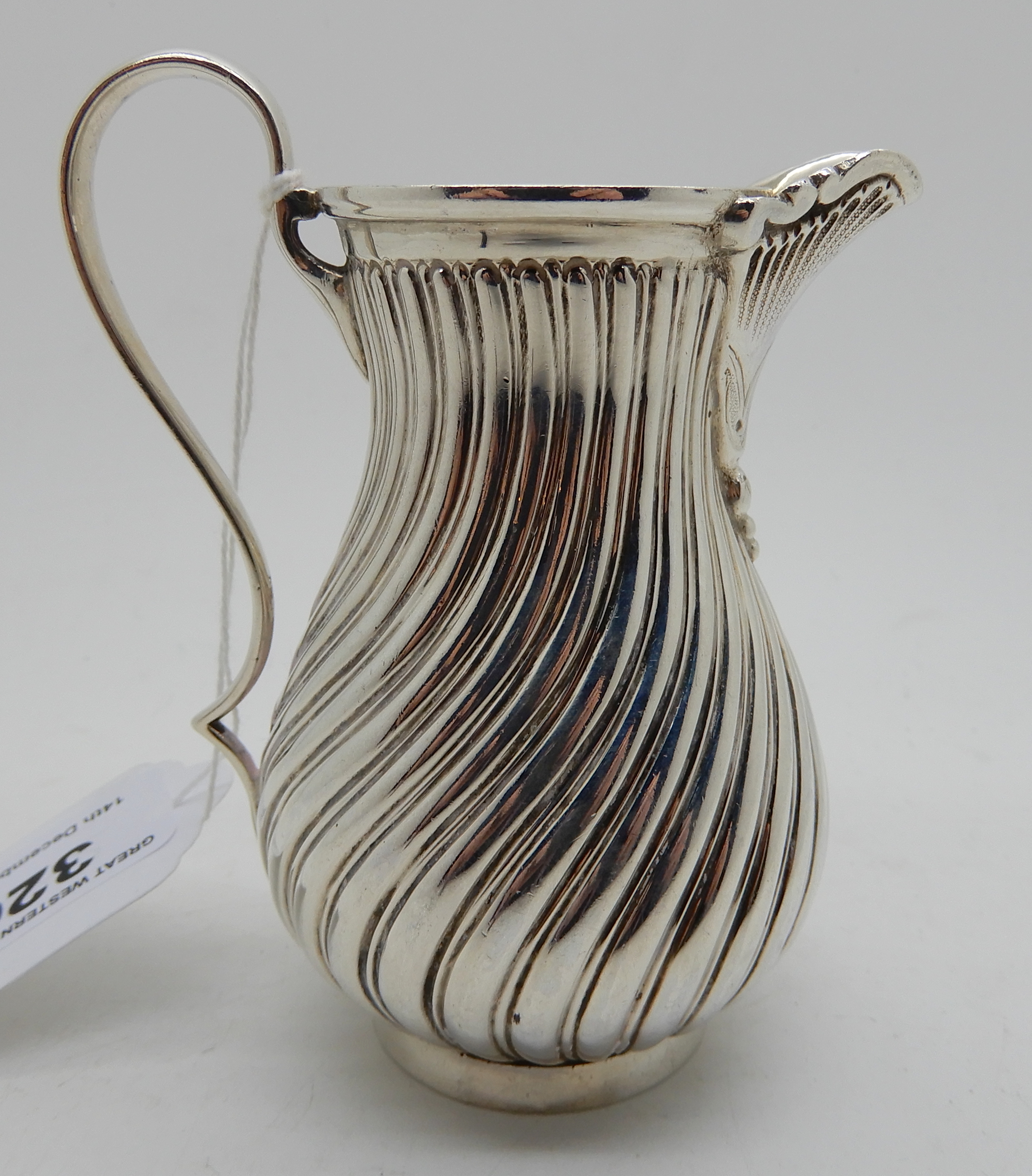 A silver cream jug by James Dixon & Sons, Sheffield 1887, of baluster shape with spiral fluting, 9cm