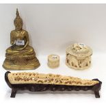 A brass figure of a cross legged Buddha, two ivory boxes and an ivory bridge depicting a village