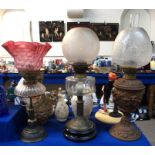 Three assorted oil lamps, one with cranberry shade Condition Report: etched shade lamp by Evered