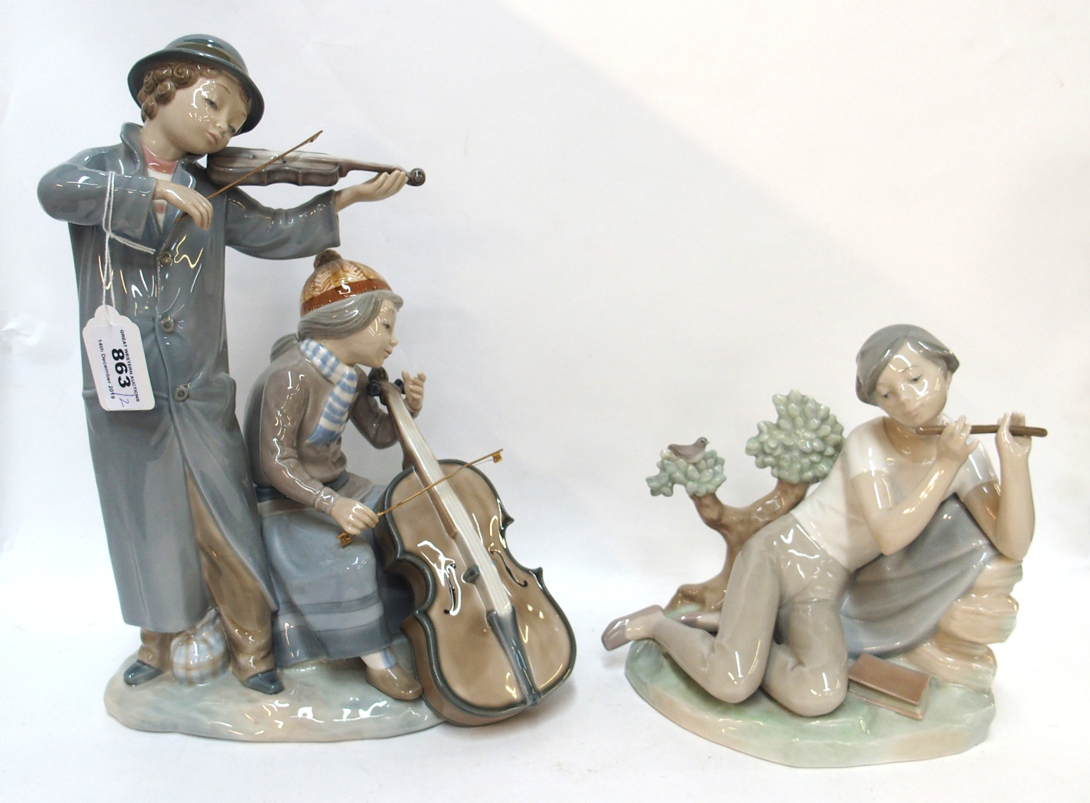 A large Nao figure of a boy playing a violin and a girl playing a cello together with a Lladro