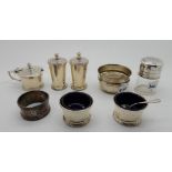 A lot comprising a three piece silver condiment set, Birmingham 1938, a pair of silver salts, a