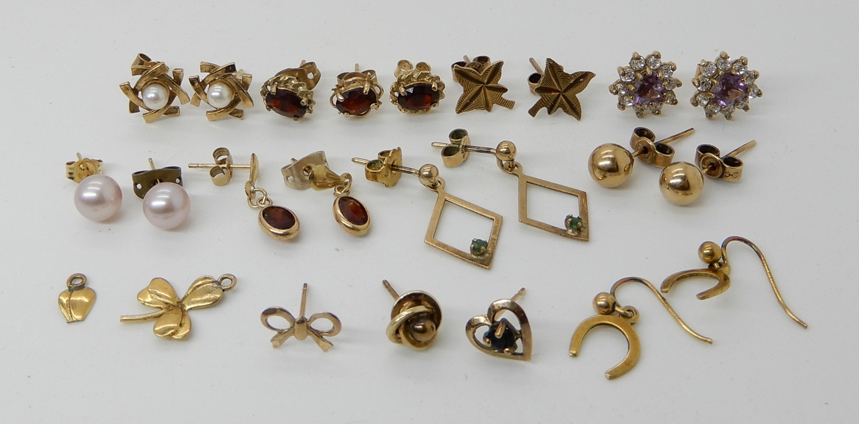 A collection of 9ct gold and yellow metal earrings, set with garnets, emerald pearls etc combined