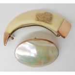 A yellow metal mounted boars tusk brooch and a 9ct gold mounted mother of pearl brooch Condition