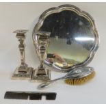 A lot comprising a pair of silver plated candlesticks, a salver, a silver hair brush and a comb
