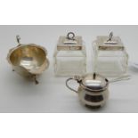 A lot comprising a pair of silver topped jam pots, Birmingham 1909, a silver sauceboat, Dublin