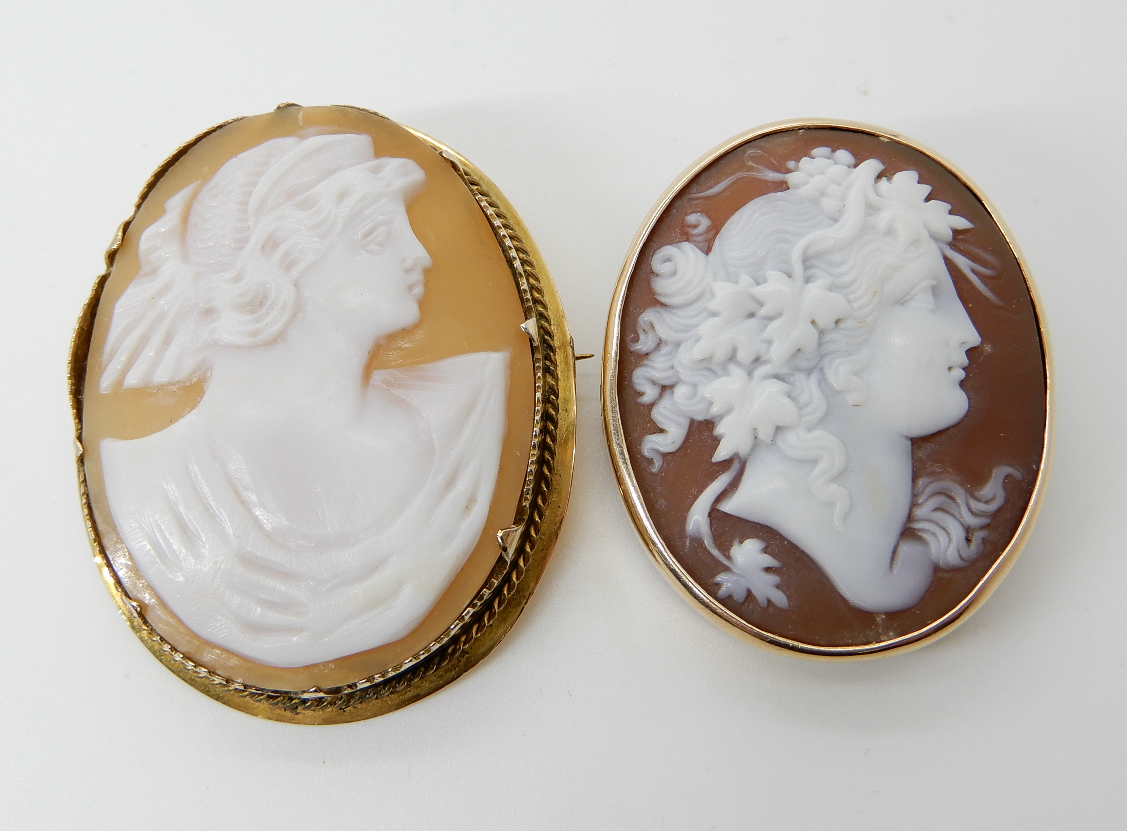 A well carved cameo of a maiden in a yellow metal brooch mount, together with another in a yellow