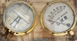 A pair of GWR brass cased locomotive gauges mounted on a board. One is a loco vacuum Brake gauge,