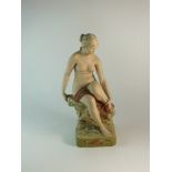 A Royal Dux figure of a nude female seated upon a rocky base