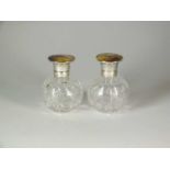 A pair of silver and Stinton enamel topped glass scent bottles