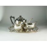 A three piece silver tea service and a silver tray