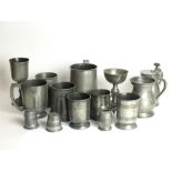 An assorted collection of 14 pewter drinking vessels, goblets, mugs, measures