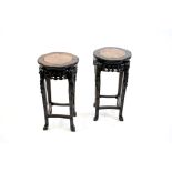 A pair of Chinese rosewood and marble inset urn stands