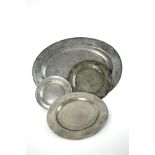 A large oval pewter dish and nine pewter plates