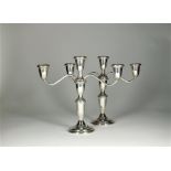 A pair of white metal mounted candelabra