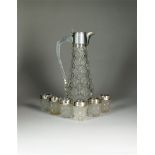 A silver mounted claret jug and tot glasses