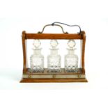 A Victorian miniature oak three decanter tantalus