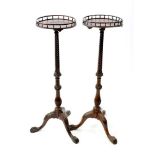 A near pair of George III style mahogany torchere stands