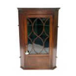 A George III mahogany veneered wall-hanging corner cupboard