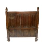 A large carved oak bed frame in the Old English style