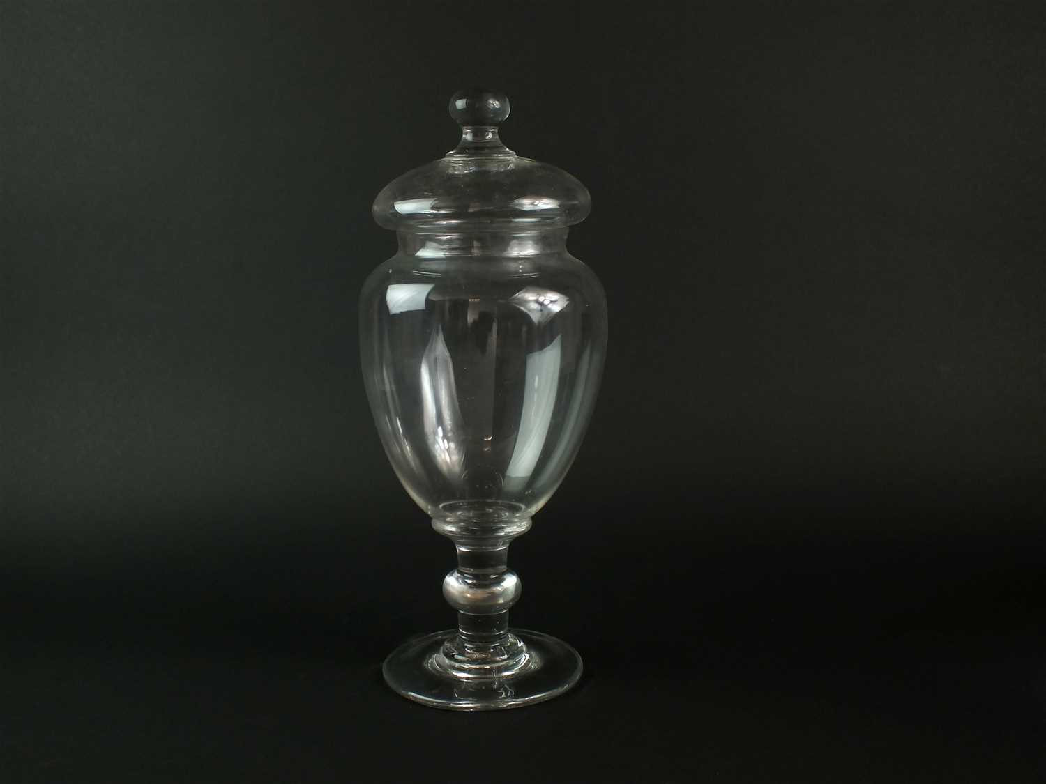 A large glass apothecary jar and cover