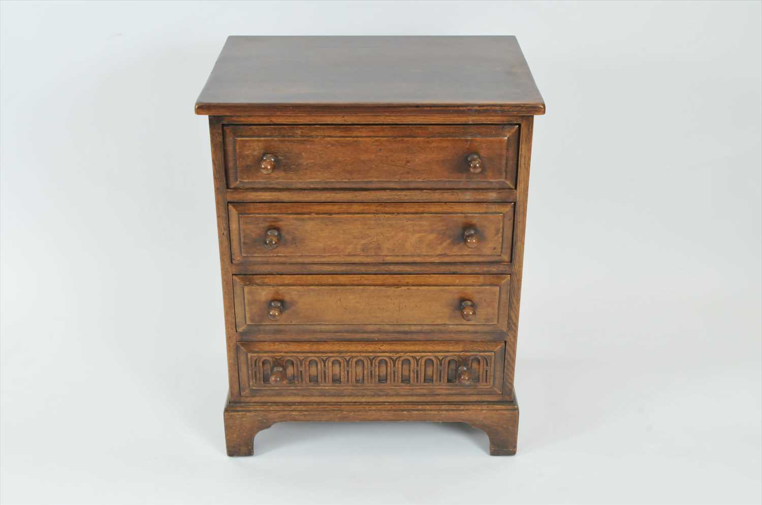 A reproduction rustic oak chest of four long drawers in the old English style