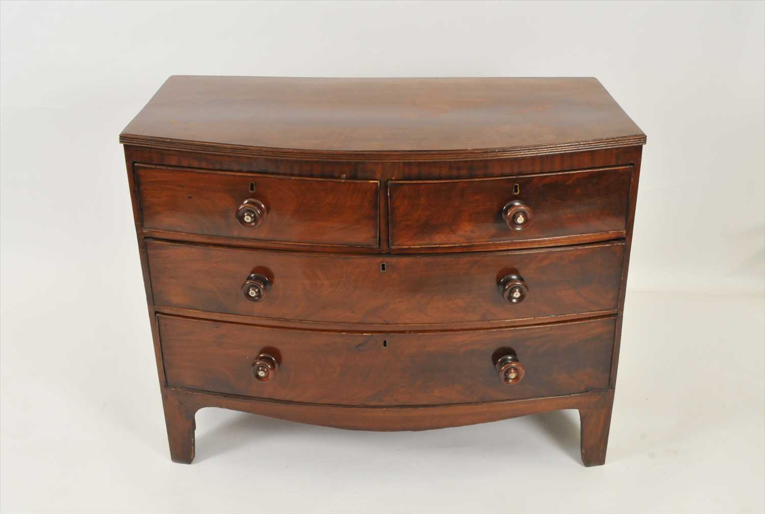 An oak topped mahogany veneered bow-fronted chest of drawers