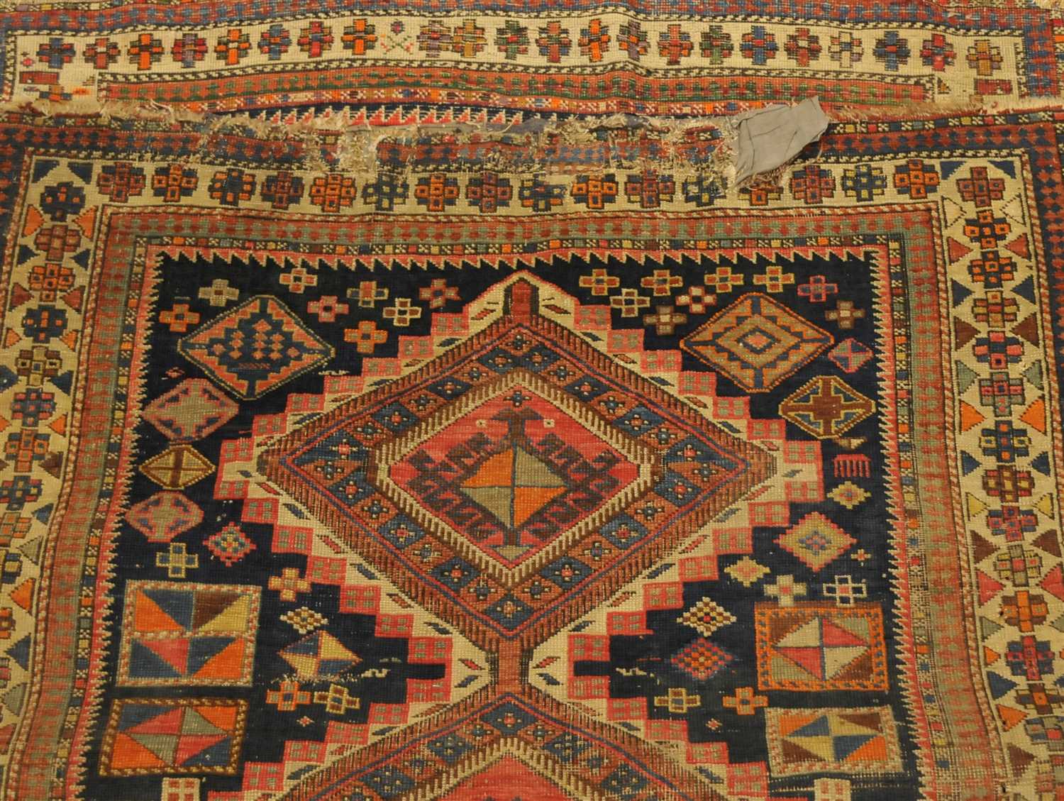 Kuba rug, North-East Caucasus, indigo field with three stepped medallions enclosed by ivory borders,