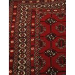An Afghan Turkmen rug, the blood red field of guls enclosed by multiple narrow borders, 173cm x