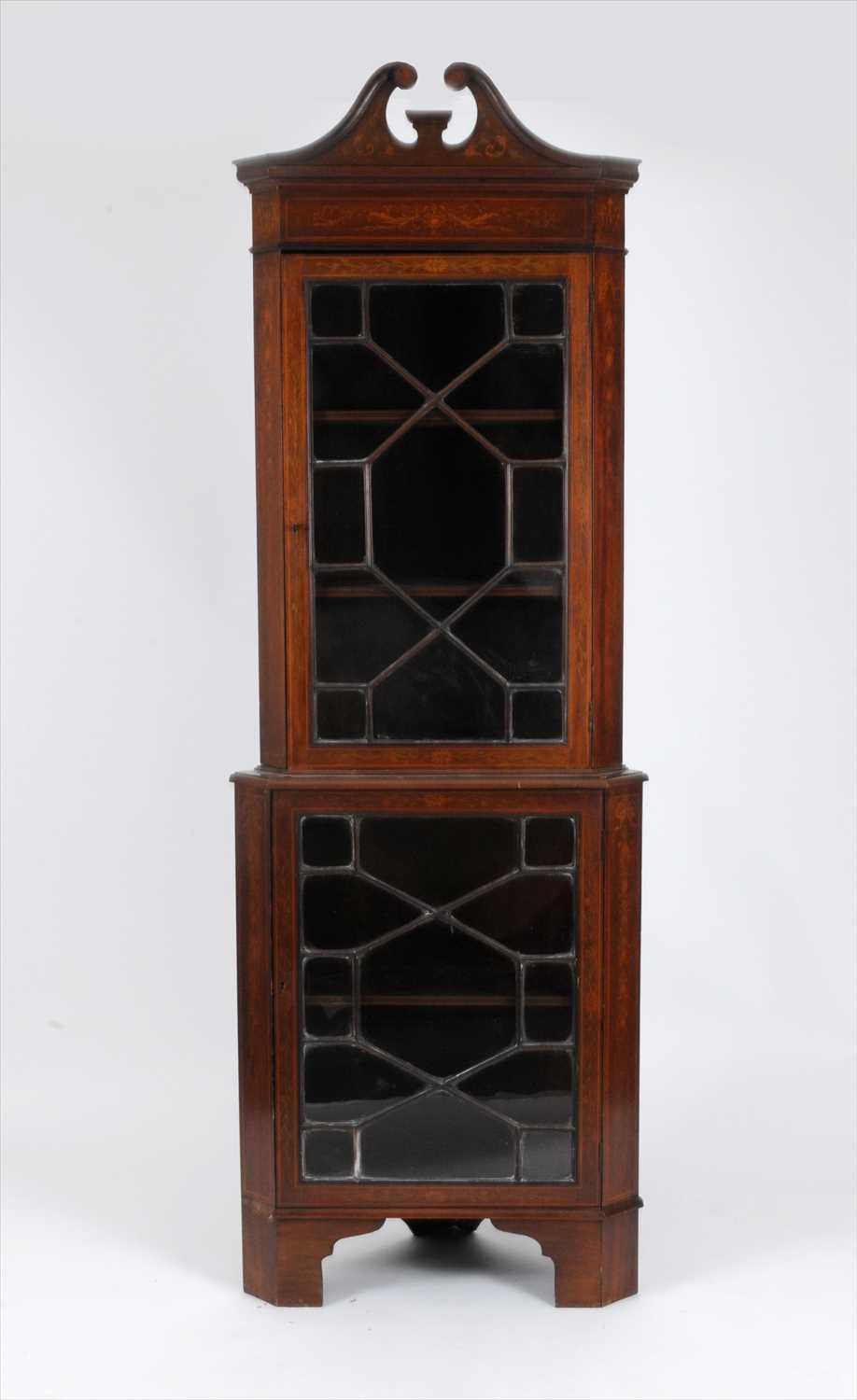 An Edwardian mahogany two sectional corner cupboard