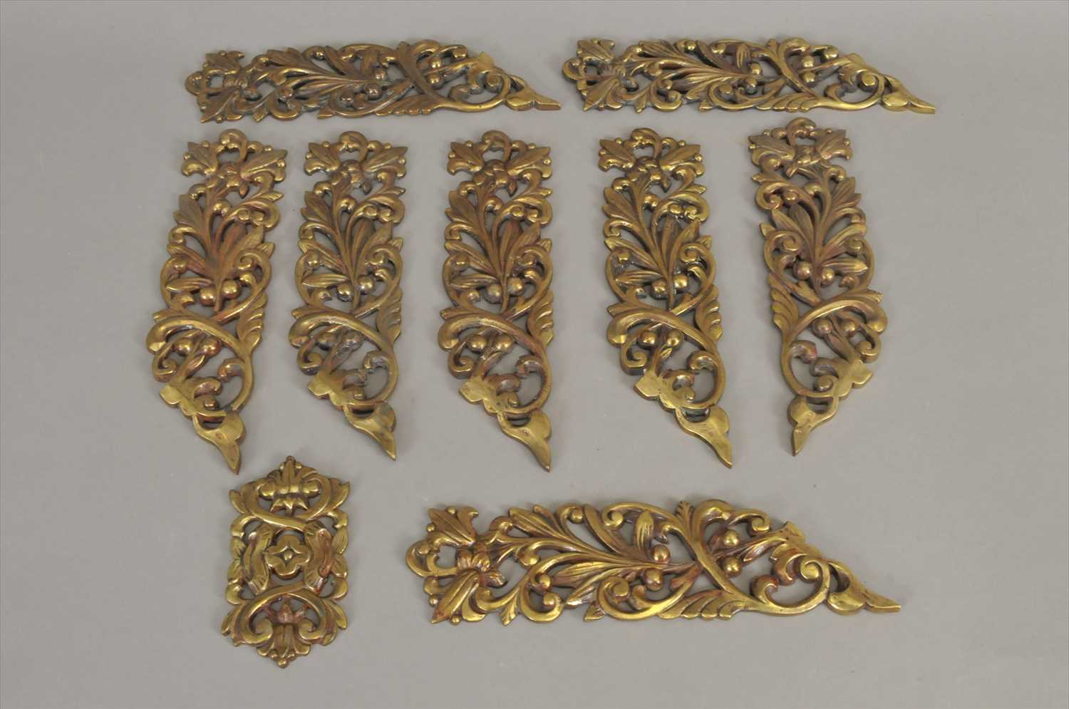 A set of eight late 19th / early 20th century pierced cast brass furniture / door mounts