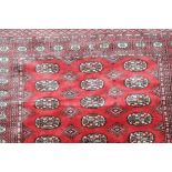 Lahore Bukhara Rug, the claret field with three columns of guls enclosed by multiple borders,