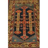 A Kurdish rug, serrated indigo field with three columns framed by spandrels and stepped gul borders,