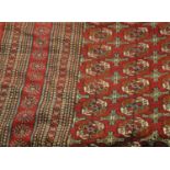 An Afghan Bukhara carpet, the raspberry field, with columns of quartered guls, enclosed by