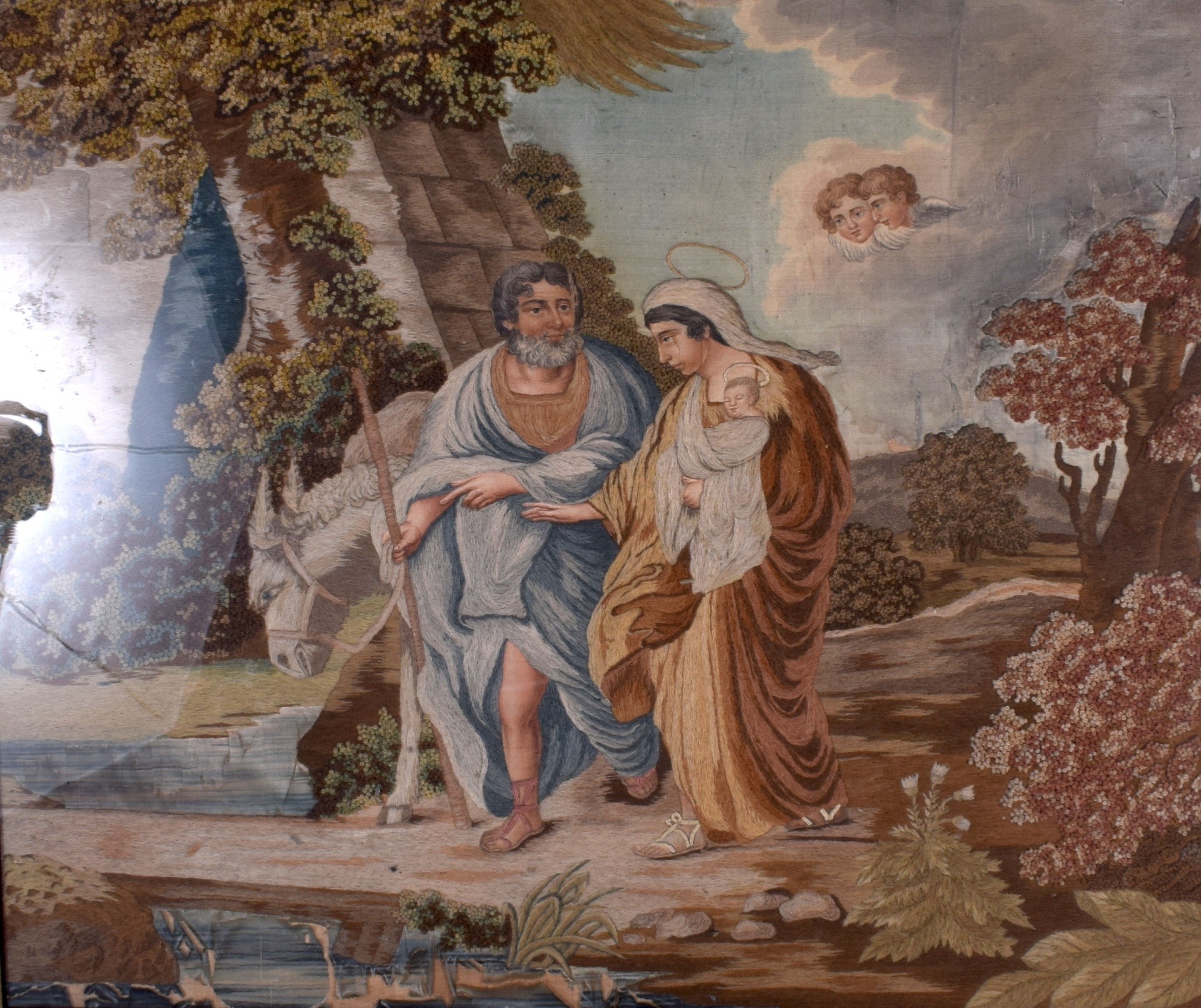 AN EARLY 20TH CENTURY FRAMED EMBROIDERY OF RELIGEOUS INTEREST, depicting Joseph, Mary and Jesus