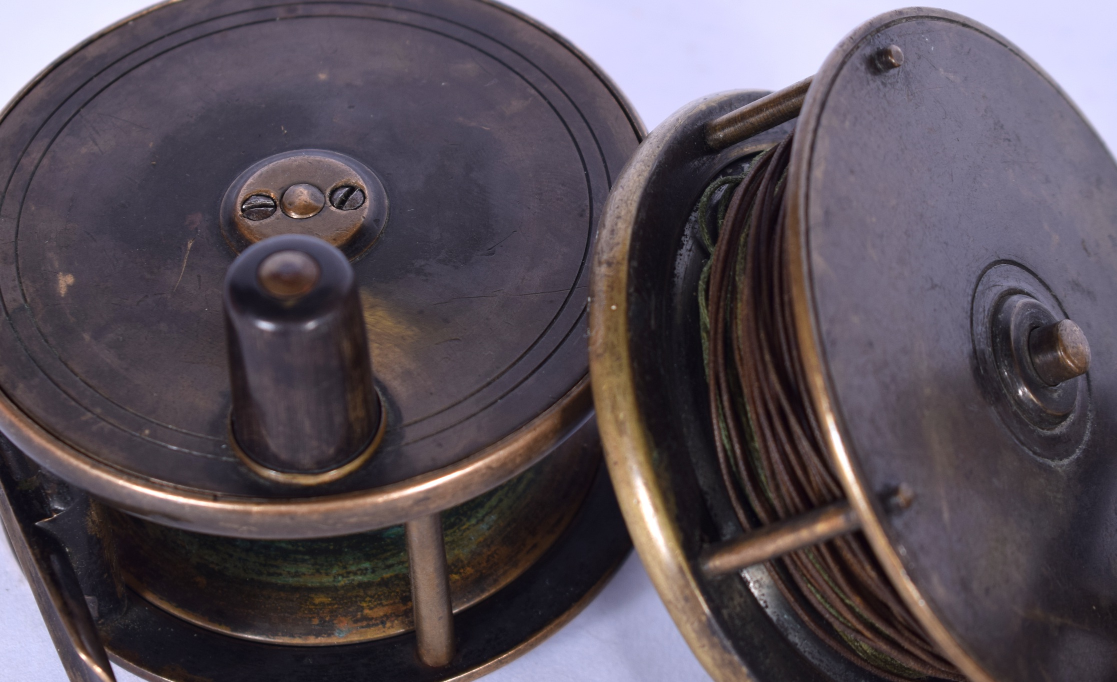 A GROUP OF FOUR ANTIQUE FISHING REELS, of varying size. Largest 10 cm. - Image 2 of 3