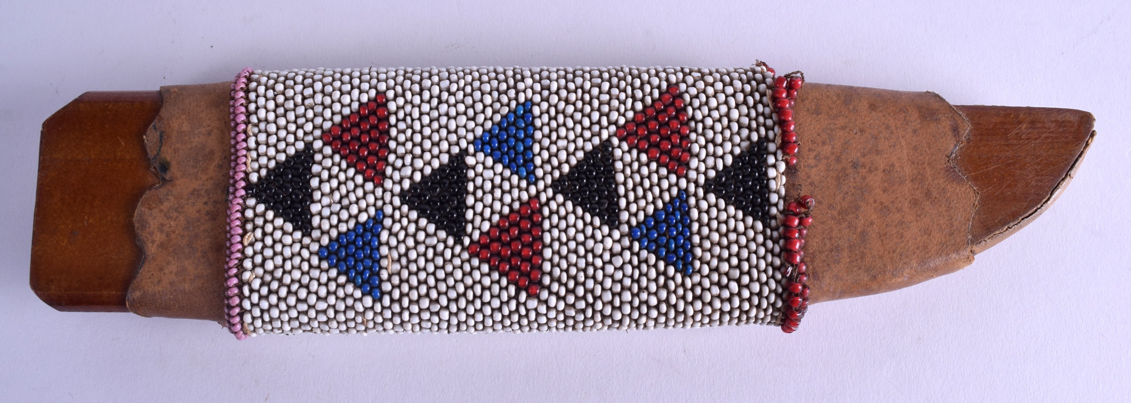 A NATIVE AMERICAN BEAD WORK KNIFE SCABBARD decorated with coloured triangular motifs. 28 cm long.