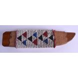 A NATIVE AMERICAN BEAD WORK KNIFE SCABBARD decorated with coloured triangular motifs. 28 cm long.