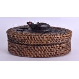 AN EARLY 20TH CENTURY TRIBAL ETHNOGRAPHICAL WICKER BOX AND COVER modelled with a recumbent frog with