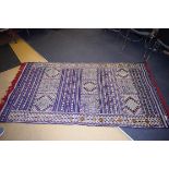 A MOROCCAN BLUE GROUND RUG,, decorated with motifs. 239 cm x 132 cm.