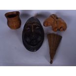 A CARVED AFRICAN STONE MASK, together with a wooden frog figure, sandalwood fan and another. Mask 29