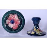 A BLUE GROUND MOORCROFT POTTERY CANDLESTICK HOLDER, together with a green ground shallow bowl.