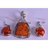 A SILVER AND AMBER PENDANT with matching earrings. (3)