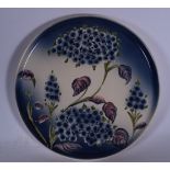 A MOORCROFT STYLE POTTERY PLAQUE OR PANEL, decorated with flowering vines. 37 cm diameter.