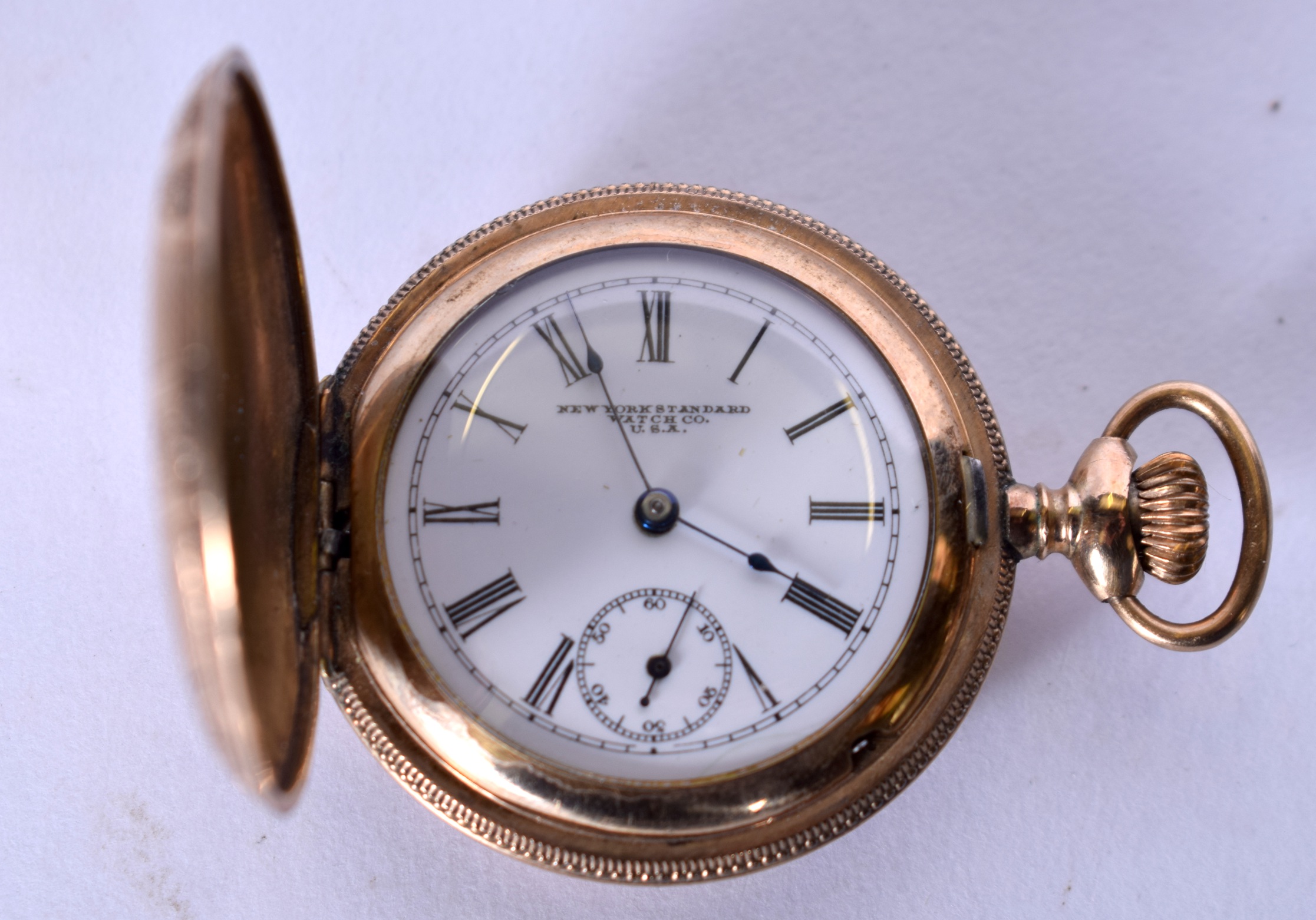 A NEW YORK STANDARD WATCH CO. YELLOW METAL POCKET WATCH, the case engraved with birds amongst