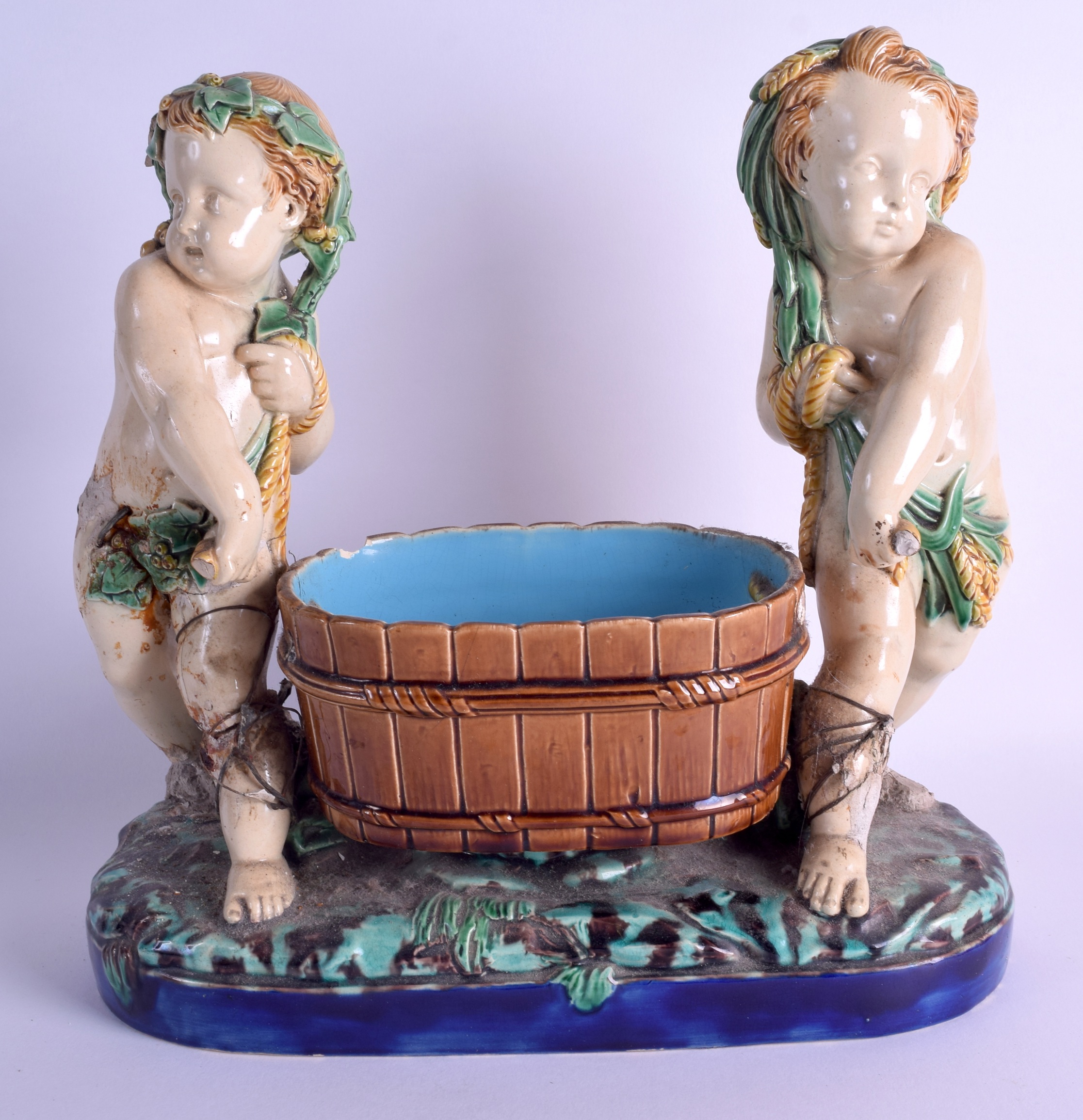 A 19TH CENTURY MINTON MAJOLICA FIGURAL GROUP depicting two putti covered in corn sheaths. 30 cm x 30