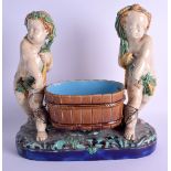 A 19TH CENTURY MINTON MAJOLICA FIGURAL GROUP depicting two putti covered in corn sheaths. 30 cm x 30