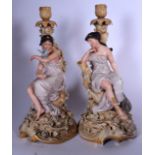 A PAIR OF EUROPEAN PORCELAIN FIGURAL CANDLESTICK, in the form of seated females on naturalistic