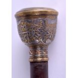 A 19TH CENTURY MIDDLE EASTERN SILVER INLAID WALKING CANE decorated with scrolling foliage and vines.