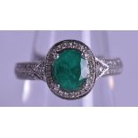 A GOOD PLATINUM DIAMOND AND EMERALD RING. Size N.